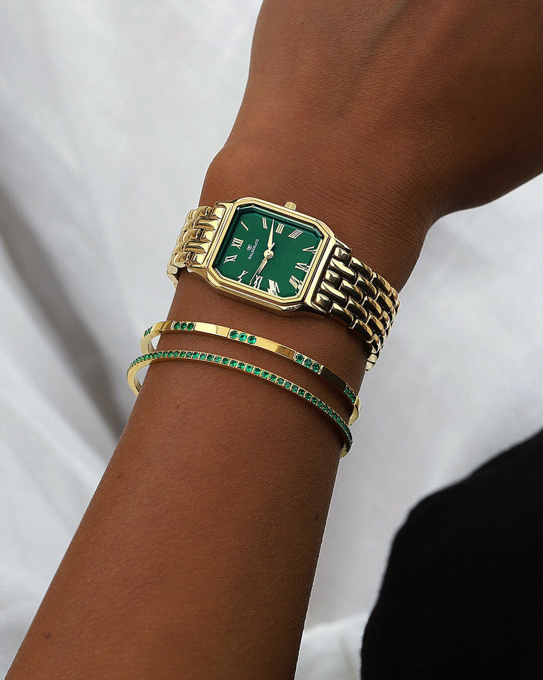 A square womens watch in 22k gold from Waldor & Co. with green Diamond Cut Sapphire Crystal glass dial. Seiko movement. The model is Eternal 22 Bellagio.