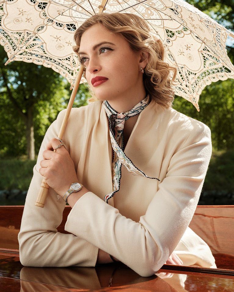 An ellipse shaped womens watch in Rhodium-plated 316L stainless steel from Waldor & Co. with silver sunray dial in brass with Greta Garbo's signature. Mineral glass with sapphire crystal coating. Seiko movement. The model is Garbo 24 Stockholm.