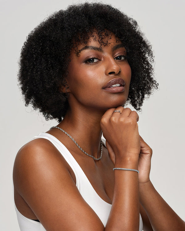 A polished stainless steel chain in silver with turquoise stones from Waldor & Co. The model is Tennis Chain Polished