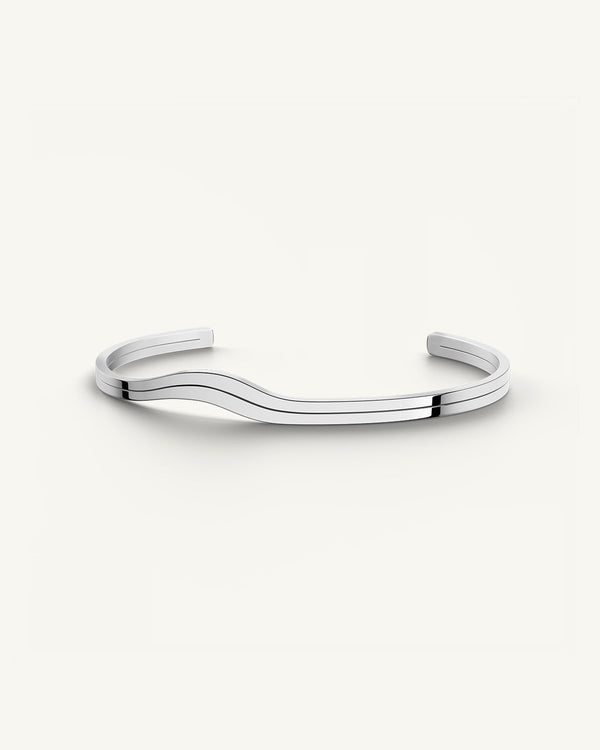 A polished stainless steel bangle in silver from Waldor & Co. One size. The model is Azur Bangle Polished.