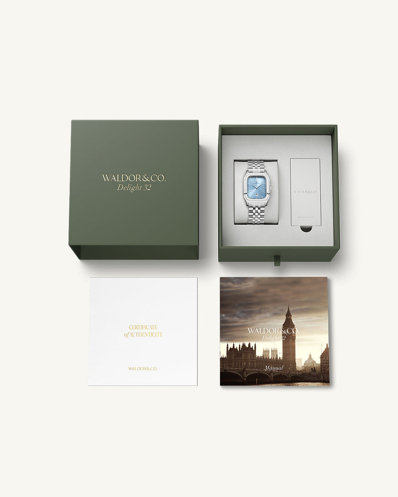 A square womens watch in silver and 14k gold from Waldor & Co. with light blue sunray dial and a second hand. Seiko movement. The model is Delight 32 Chelsea 28x32mm.