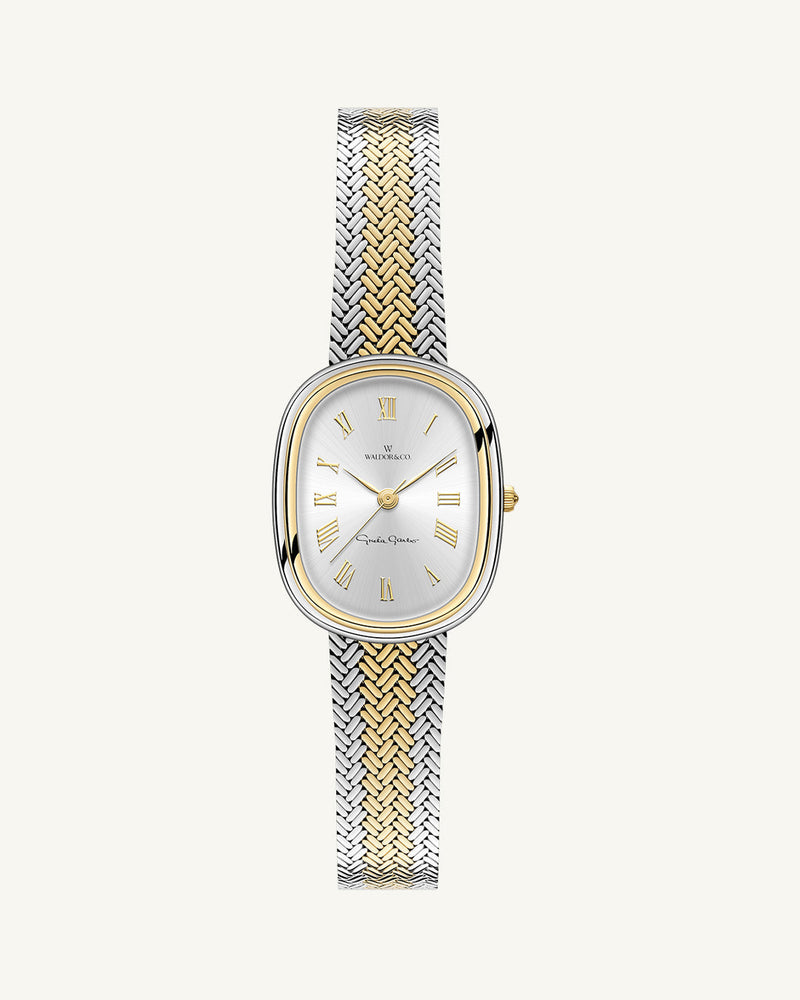 An oval womens watch created under exclusive license from the Greta Garbo™ estate. Featuring a silver sunray dial with gold Roman numerals, framed in a dual-tone case. Seiko movement. 