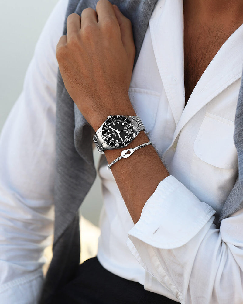 A round mens watch in Rhodium-plated 316L stainless steel from Waldor & Co. with Black dial in brass with a rotating bezel. Applied indices, luminous hands. Ronda 715. The model is Novel 40 Cap d’Ail 40mm.